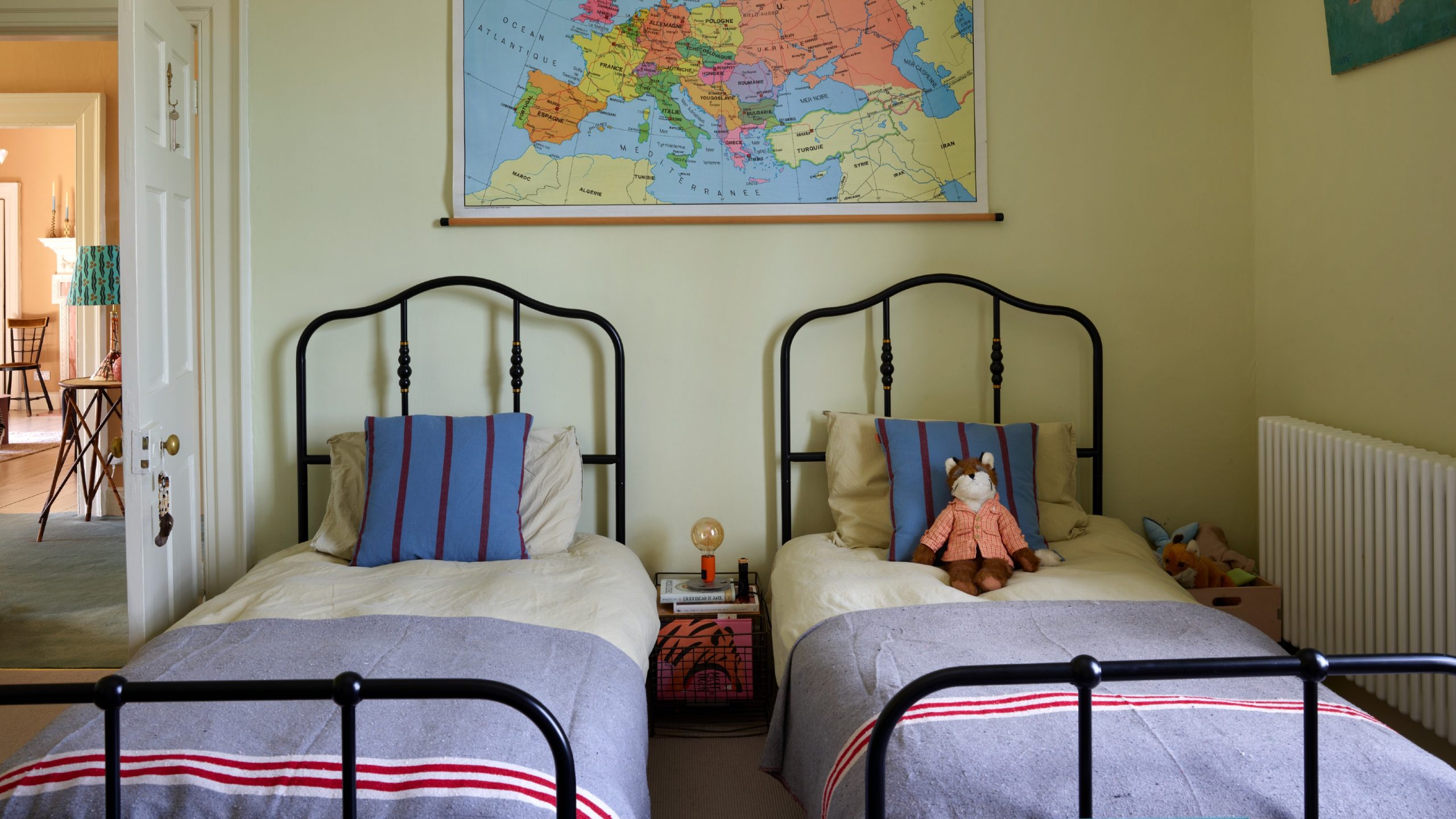 Twin Metal Beds with Map Art and Warm Green Walls