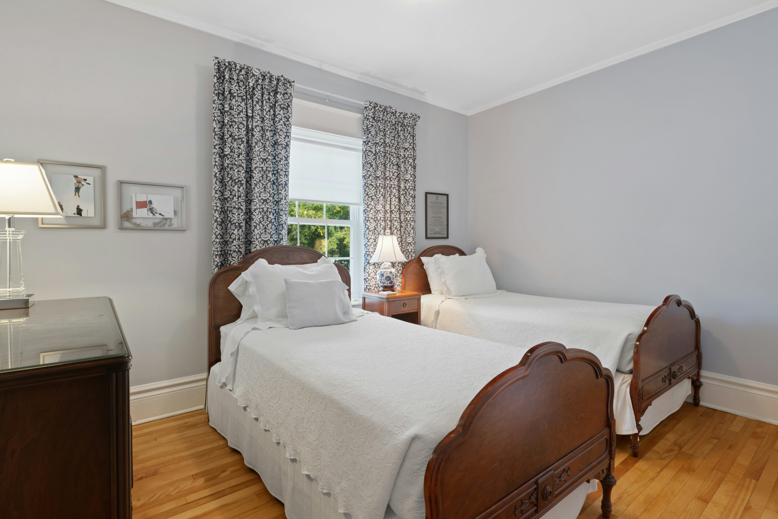 Traditional Twin Shared Bedroom with Dark Wood Beds and Floral Curtains