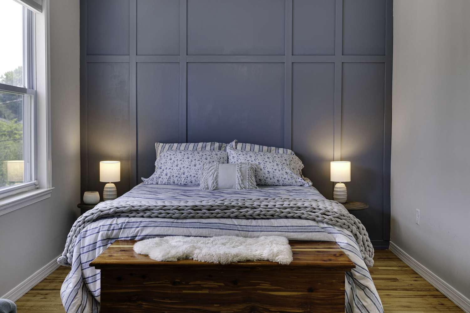Cozy Blue Panel Wall Bedroom with Striped Bedding