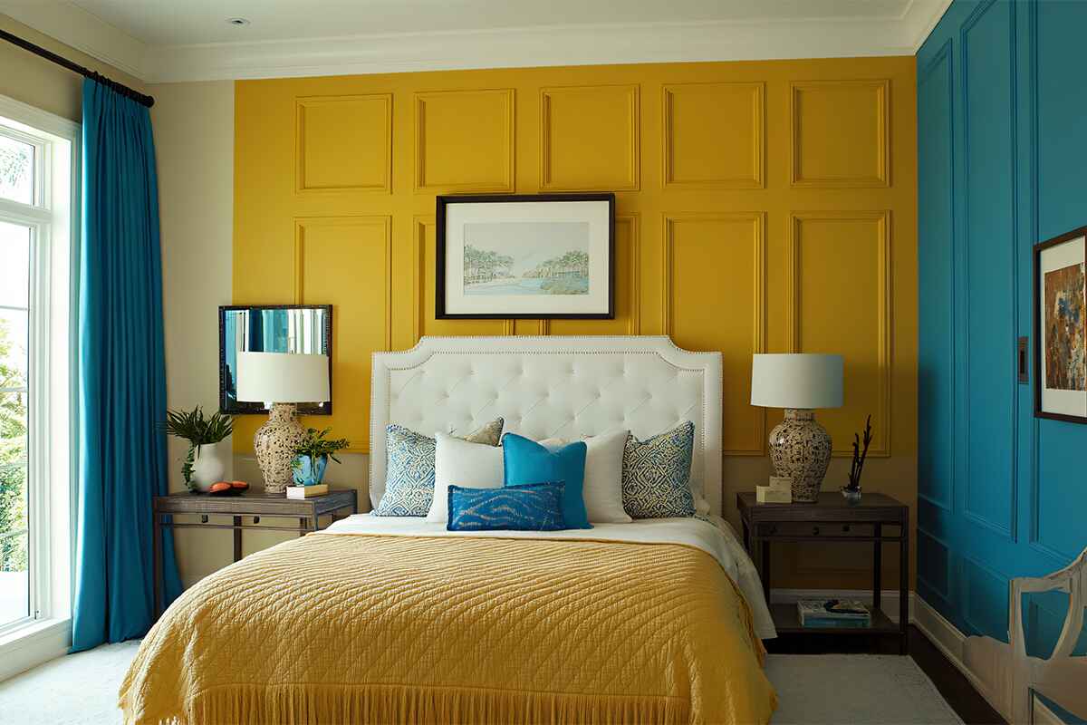 Saffron and Teal Paneled Walls with Tufted Headboard