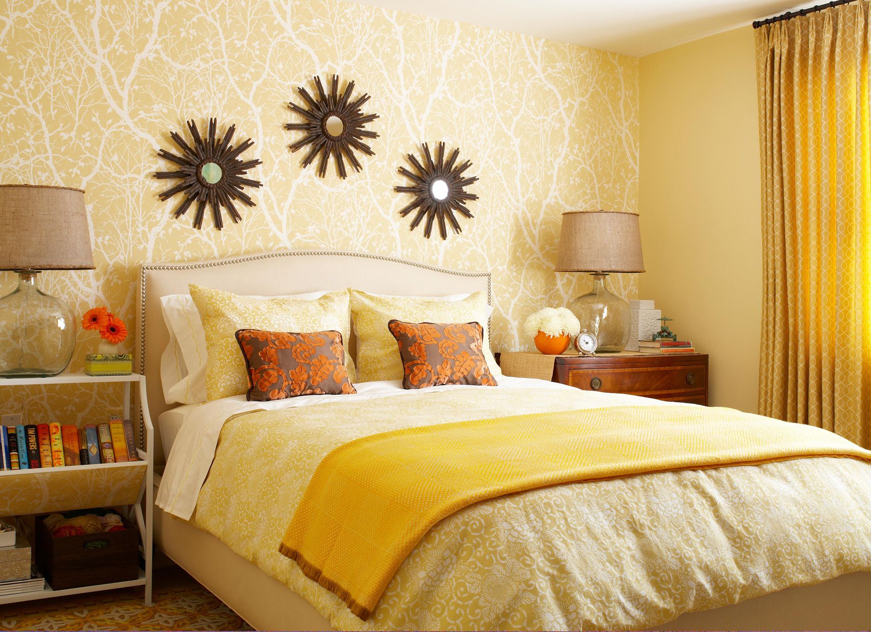 Yellow Bedroom with Patterned Wallpaper and Sunburst Mirrors