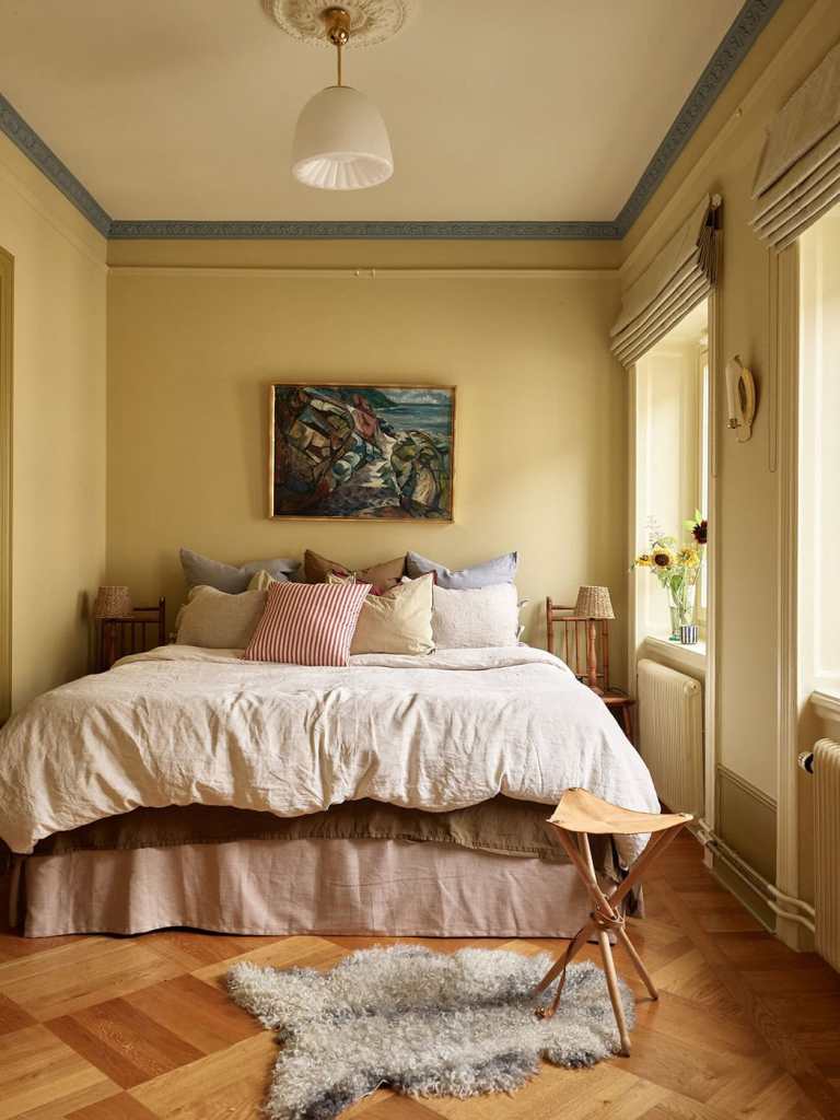 Warm Yellow Bedroom with Eclectic Decor and Wood Flooring