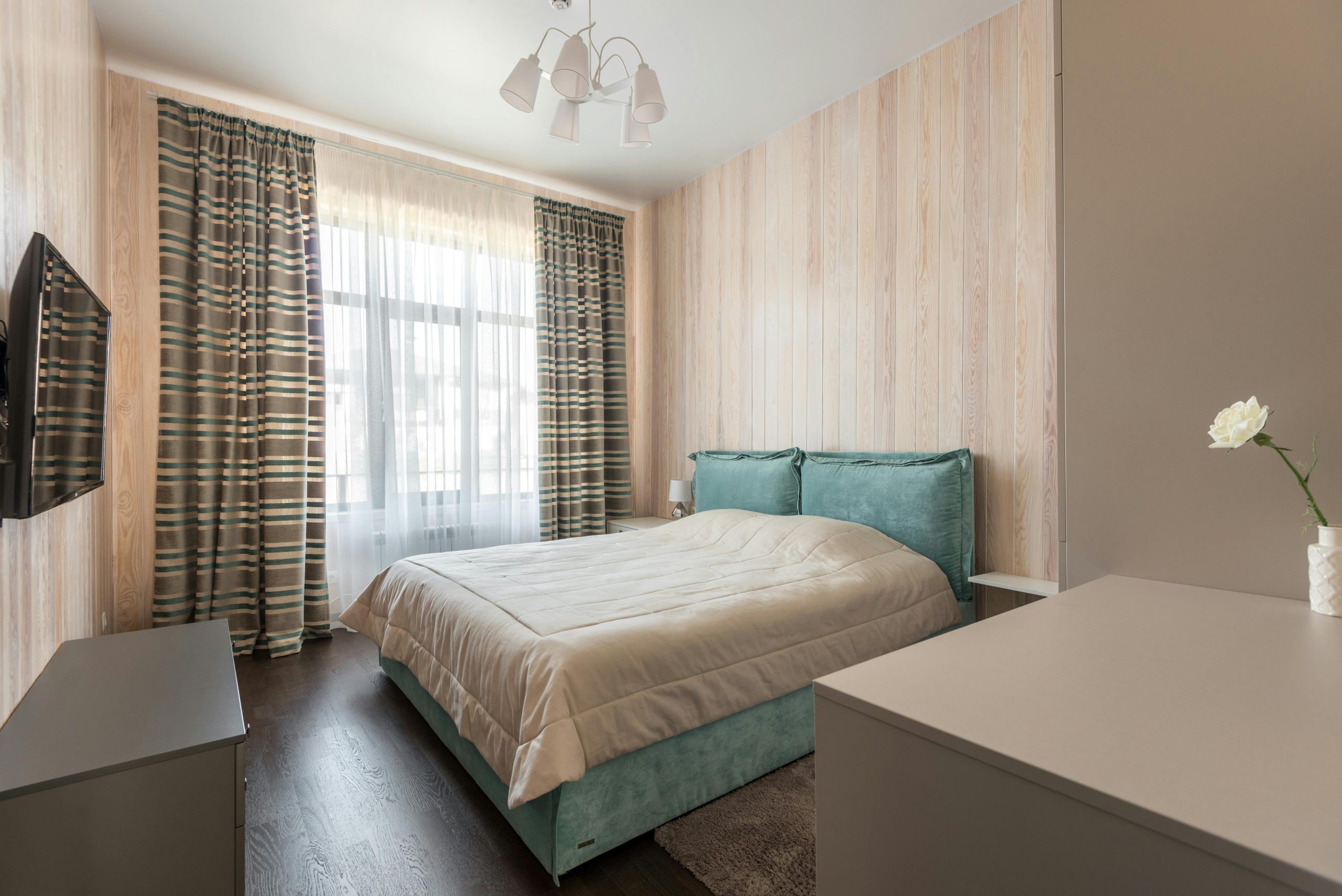 Modern Bedroom with Light Wood Paneling and Teal Bed