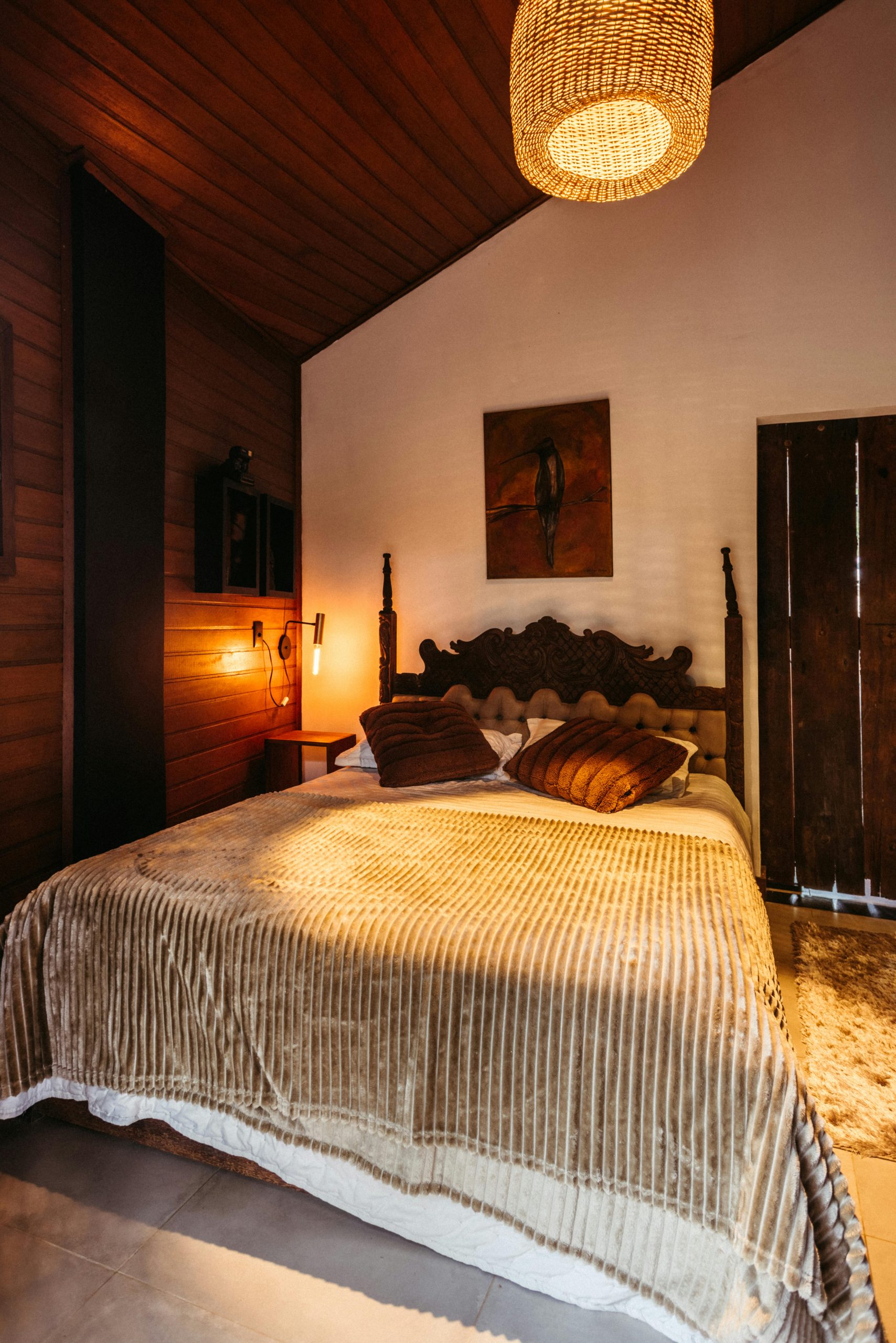 17. Deep Wood Retreat with Carved Headboard and Rattan