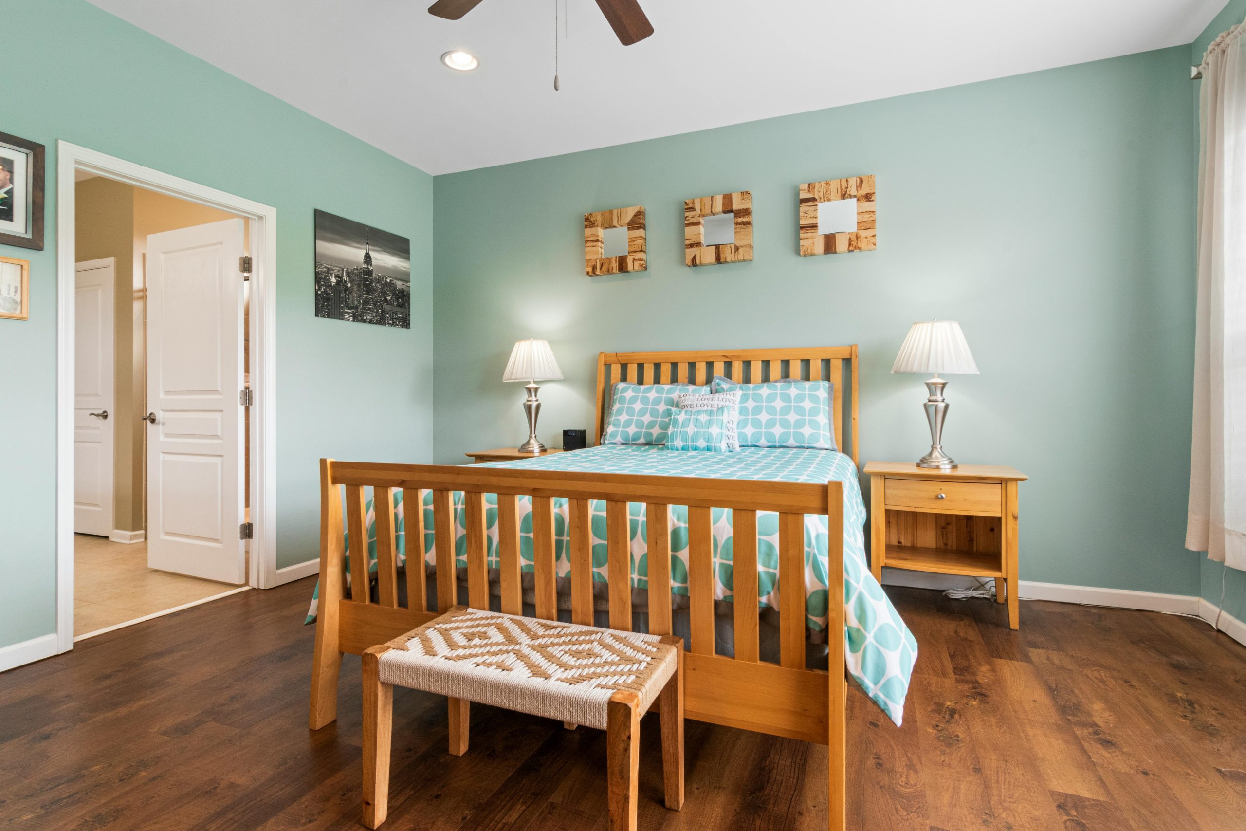 20. Uplifting Teal Walls with Light Wood Furnishings