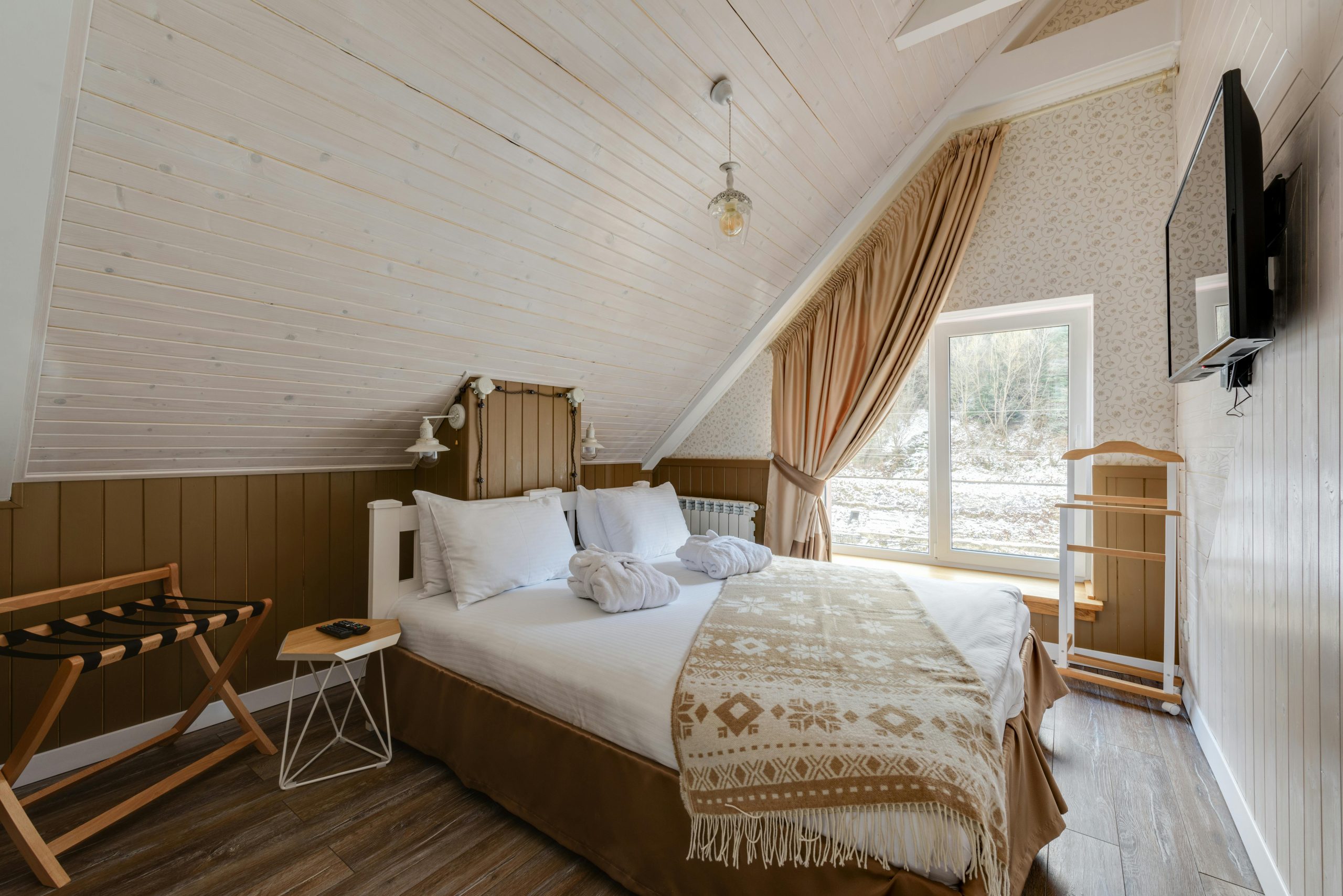 23. Cozy Attic Retreat with Sloped Walls and Wood Paneling